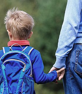 little boy holding adults hand