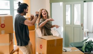 unmarried couple moving boxes into new home