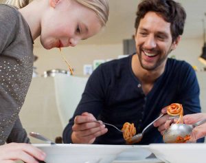 Father and daughter eating dinner in their new home