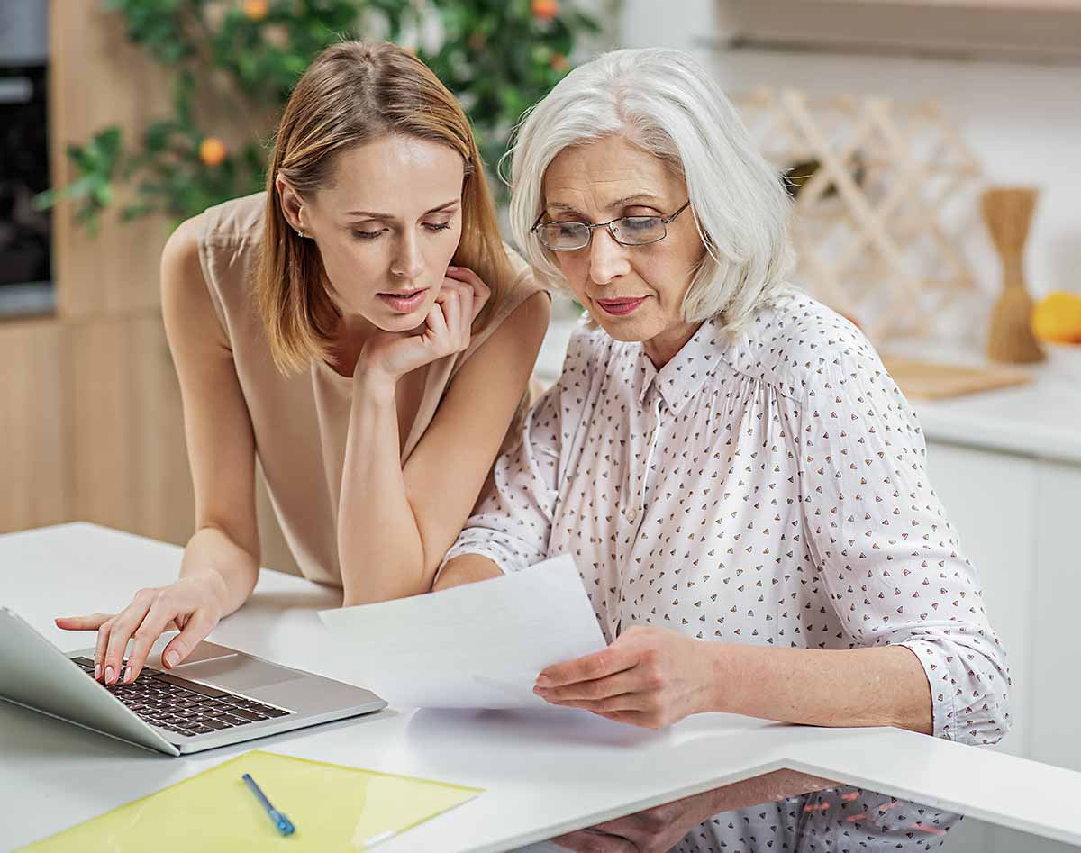 Elderly mother and daughter reviewing Will and paperwork