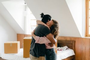 Couple hugging during house move